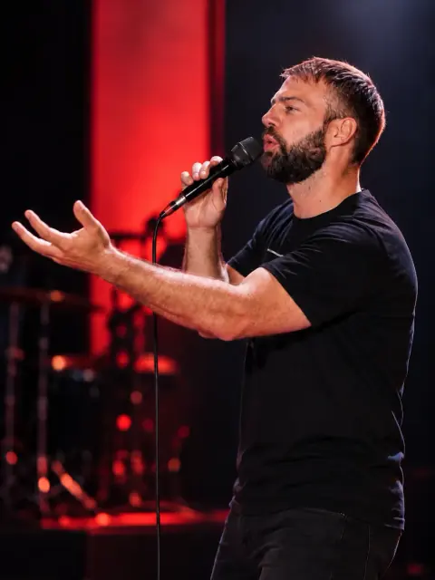 Marijan Monić pjeva na pozornici s mikrofonom u ruci